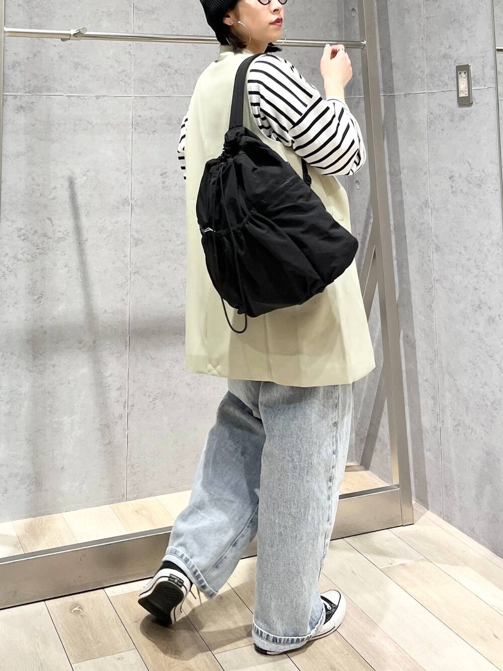 ブラック系のバックパック/リュック、ブルー系のTシャツ/カットソー、ブルー系のデニムパンツを着用したレディースの冬コーディネートの4枚目の写真