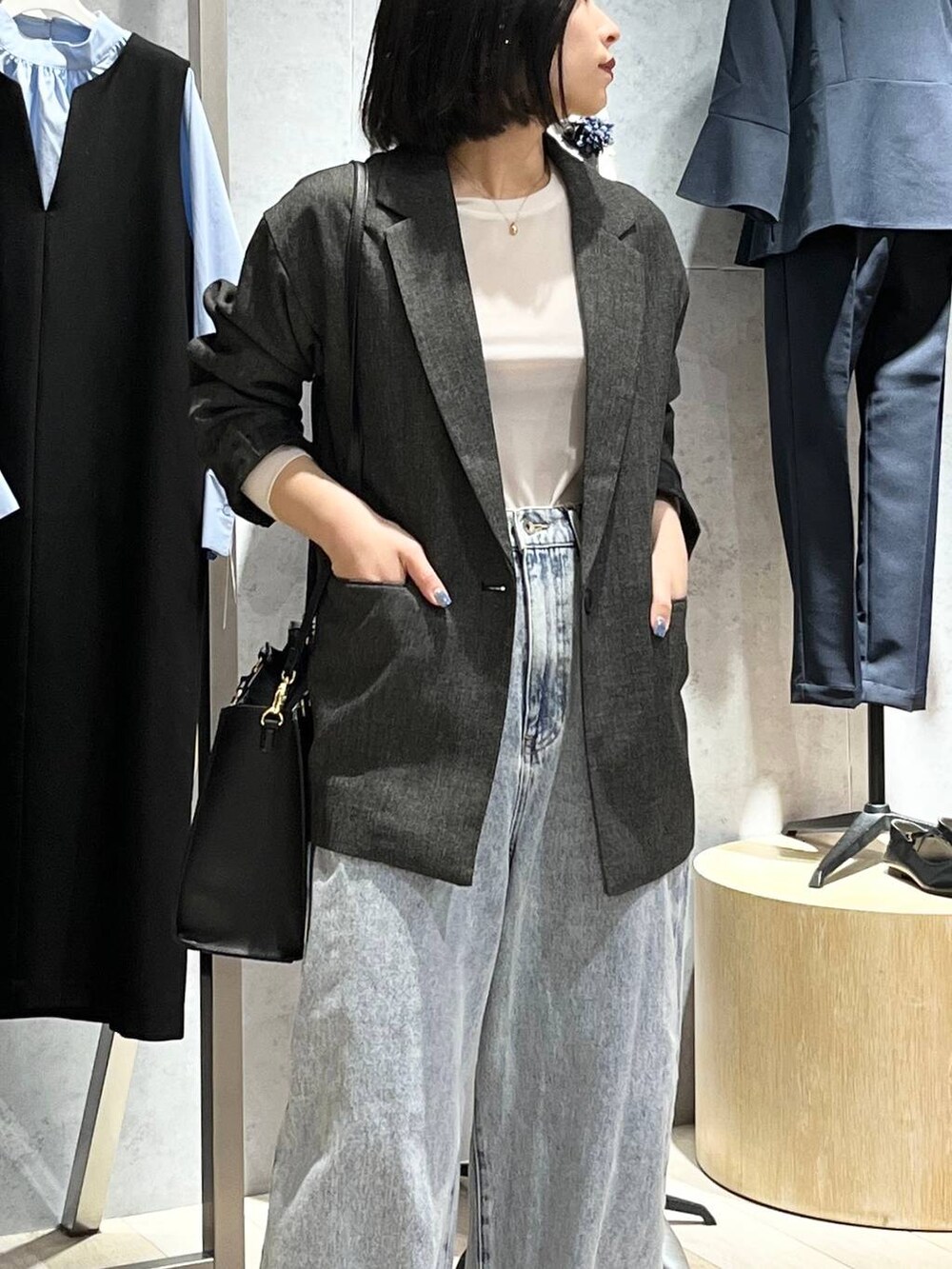 ホワイト系のTシャツ/カットソー、ブルー系のデニムパンツ、ブラック系のショルダーバッグを着用したレディースの冬コーディネートの6枚目の写真