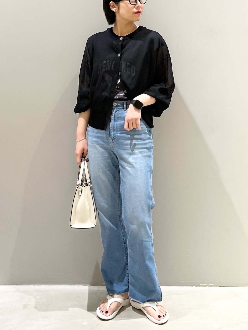 ホワイト系のサンダル、ホワイト系のショルダーバッグ、ブルー系のデニムパンツを着用したレディースの夏コーディネートの6枚目の写真