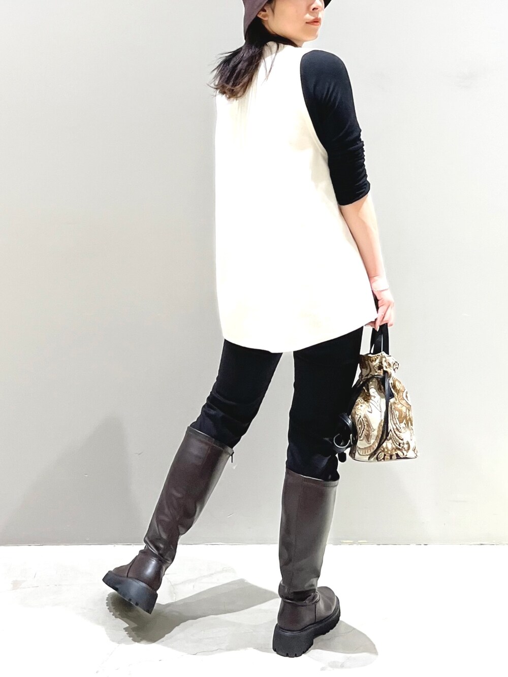 ブラウン系のショルダーバッグ、ブラウン系のブーツ、ブラック系のその他パンツを着用したレディースの秋コーディネートの2枚目の写真