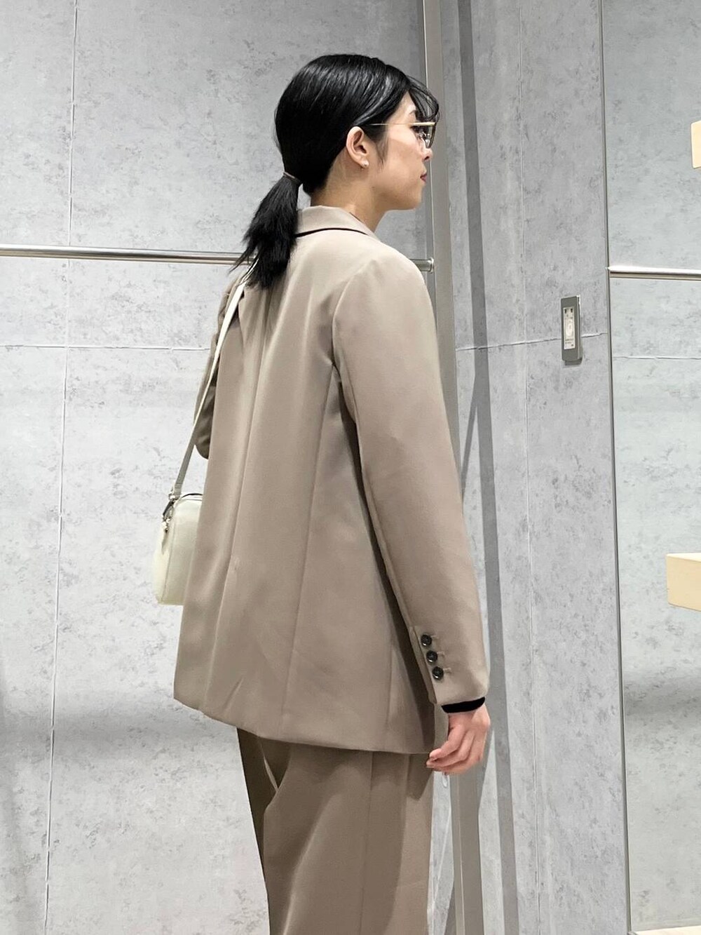 ブラック系のニット/セーター、ブラウン系のスーツパンツ、ブラック系のパンプスを着用したレディースの冬コーディネートの5枚目の写真