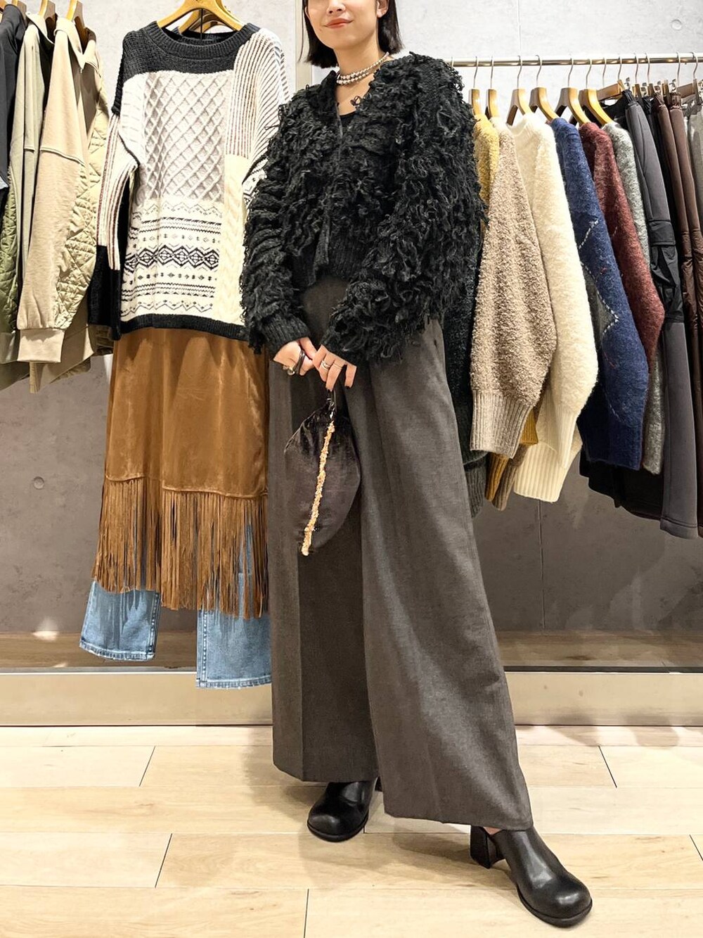 ブラック系のその他シューズ、グレー系のその他パンツ、ブラウン系のショルダーバッグを着用したレディースの秋コーディネートの2枚目の写真