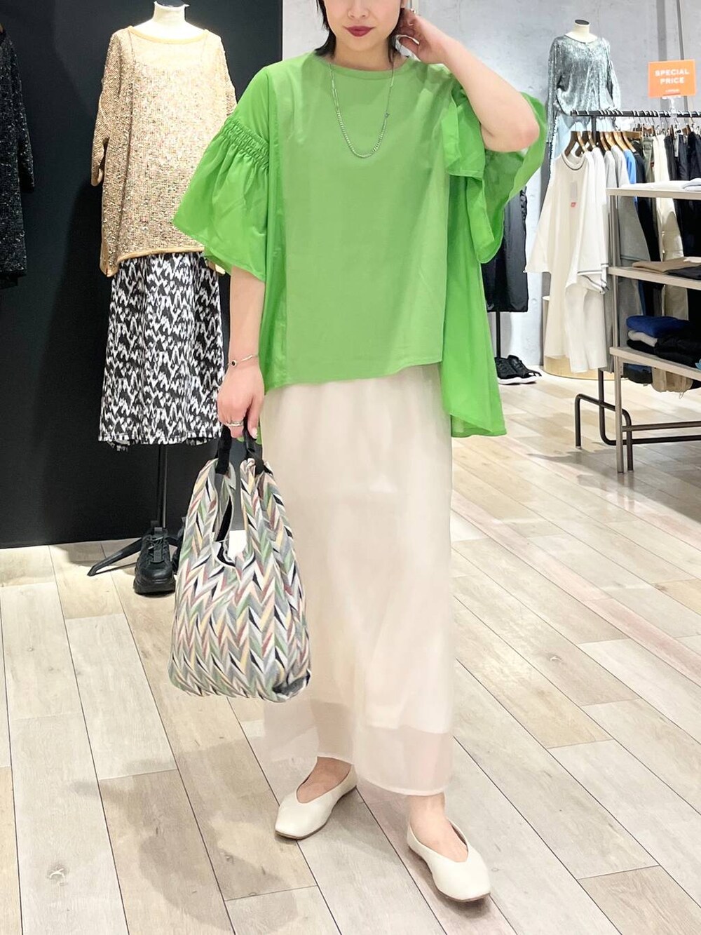 ホワイト系のハンドバッグ、ホワイト系のパンプス、ホワイト系のスカートを着用したレディースの春コーディネートの5枚目の写真