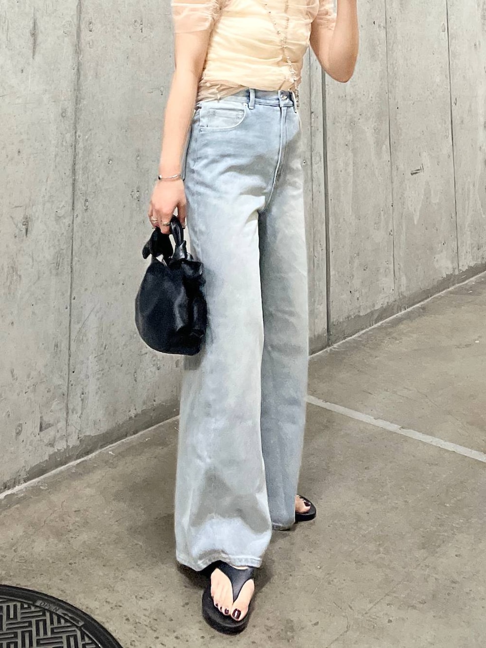 ホワイト系のキャミソール、ブルー系のデニムパンツ、ブラック系のサンダルを着用したレディースの夏コーディネートの5枚目の写真