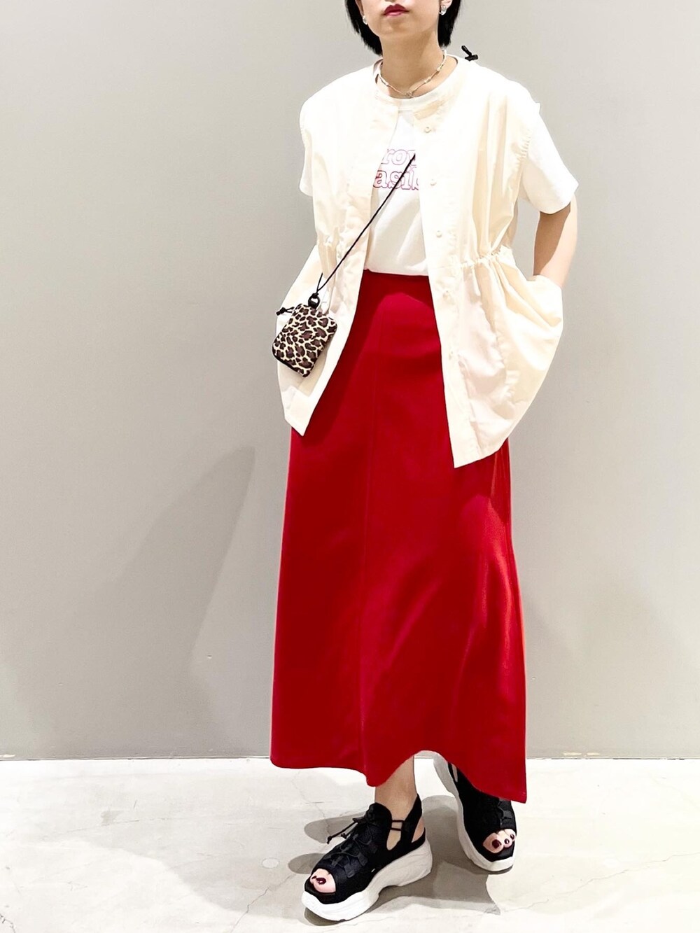 レッド系のスカート、ブラック系のサンダル、ホワイト系のシャツ/ブラウスを着用したレディースの夏コーディネートの4枚目の写真