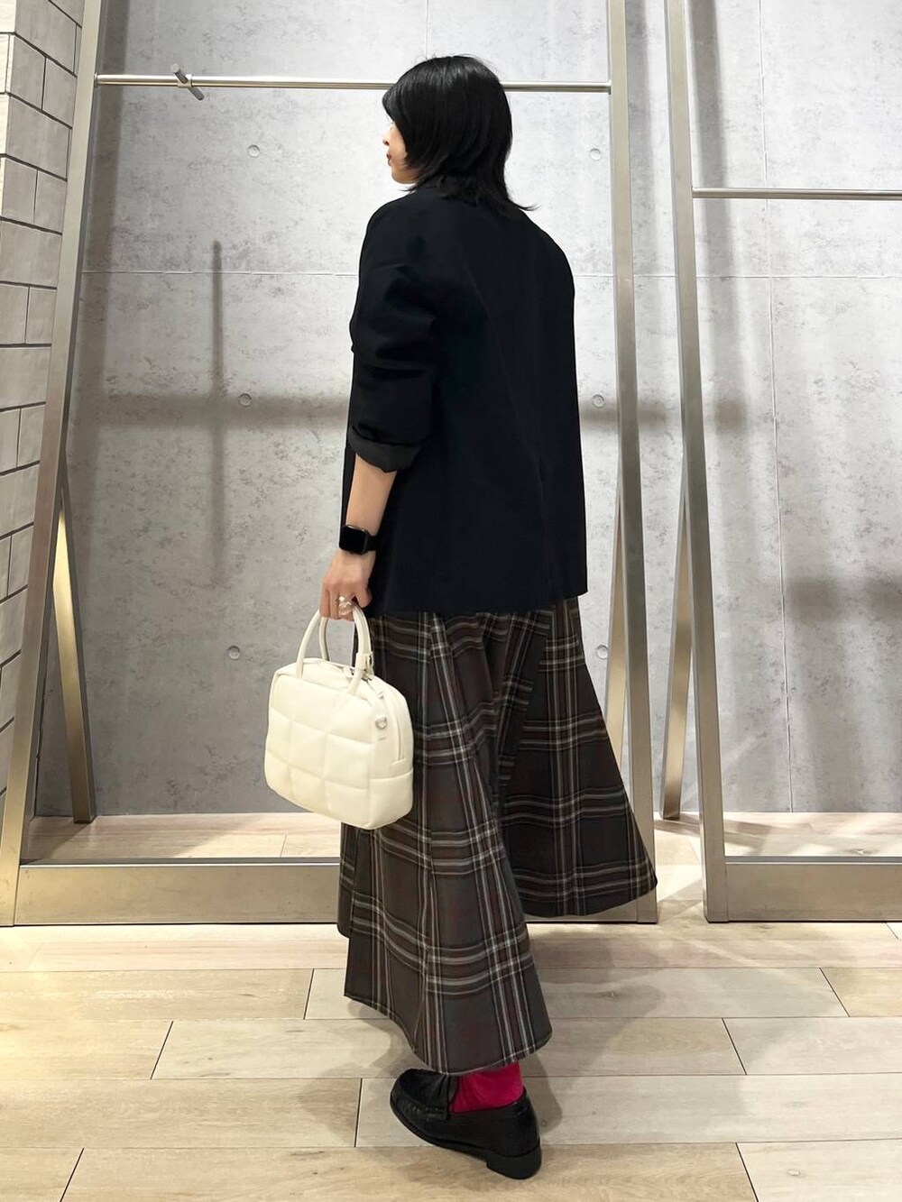 ブルー系のテーラードジャケット、ホワイト系のボストンバッグ、ブラック系のローファーを着用したレディースの秋コーディネートの4枚目の写真
