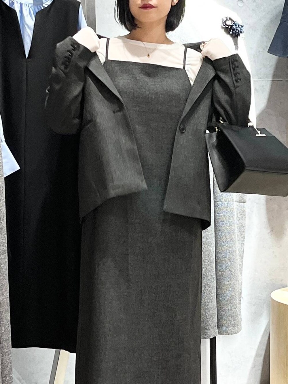 ホワイト系のTシャツ/カットソー、ブラック系のパンプス、ブラック系のショルダーバッグを着用したレディースの冬コーディネートの4枚目の写真