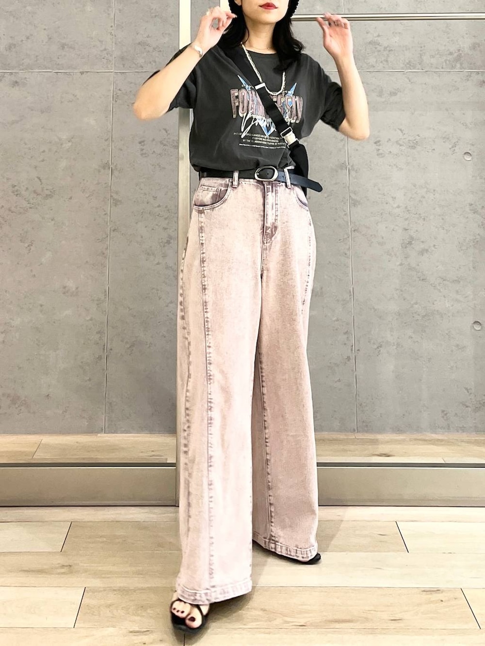 パープル系のデニムパンツ、ブラック系のショルダーバッグ、ブラック系のTシャツ/カットソーを着用したレディースの春コーディネートの9枚目の写真