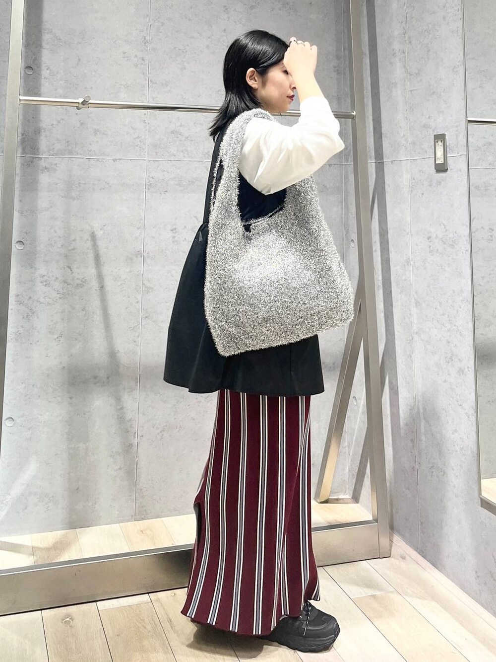 シルバー系のショルダーバッグ、レッド系のスカート、ブラック系のワンピースを着用したレディースの秋コーディネートの6枚目の写真