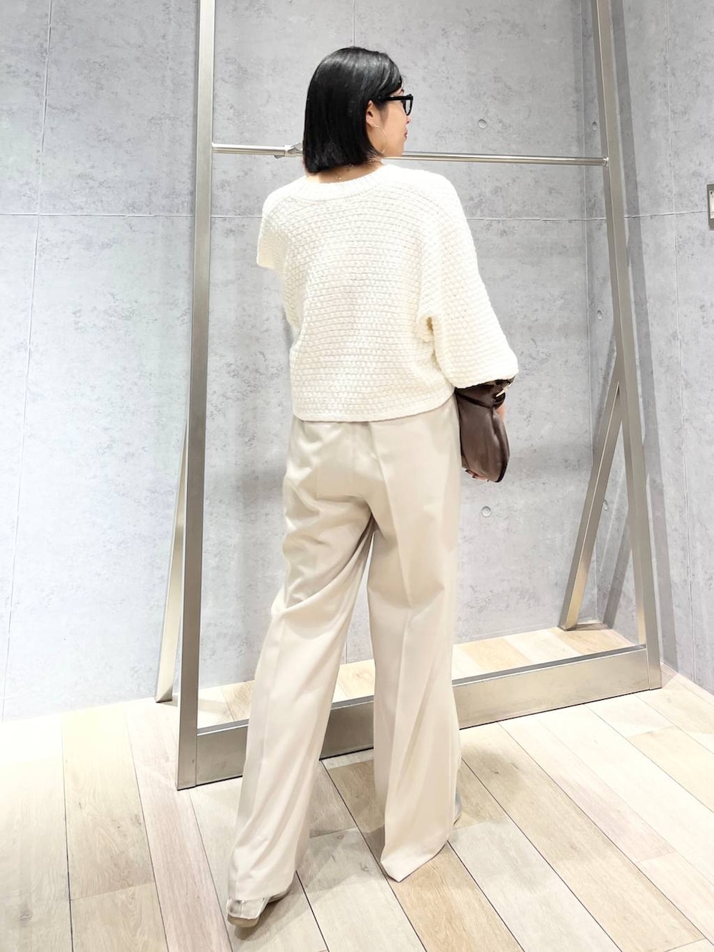 ブラウン系のハンドバッグ、グレー系のパンプス、ホワイト系のカーディガン/ボレロを着用したレディースの冬コーディネートの6枚目の写真