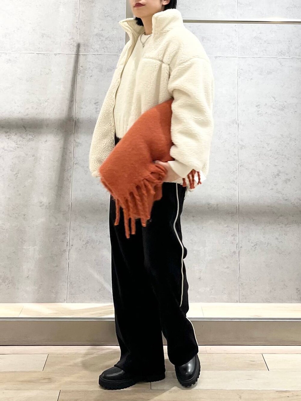 ブラック系のブーツ、ホワイト系のニット/セーター、ホワイト系のその他アウターを着用したレディースの冬コーディネートの6枚目の写真