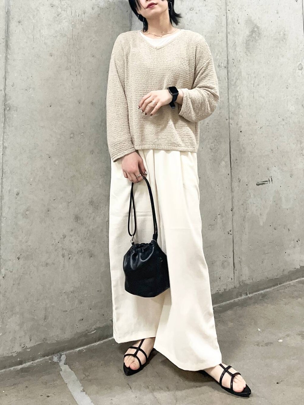 ブラック系のショルダーバッグ、ブラック系のサンダル、ホワイト系のTシャツ/カットソーを着用したレディースの春コーディネートの7枚目の写真