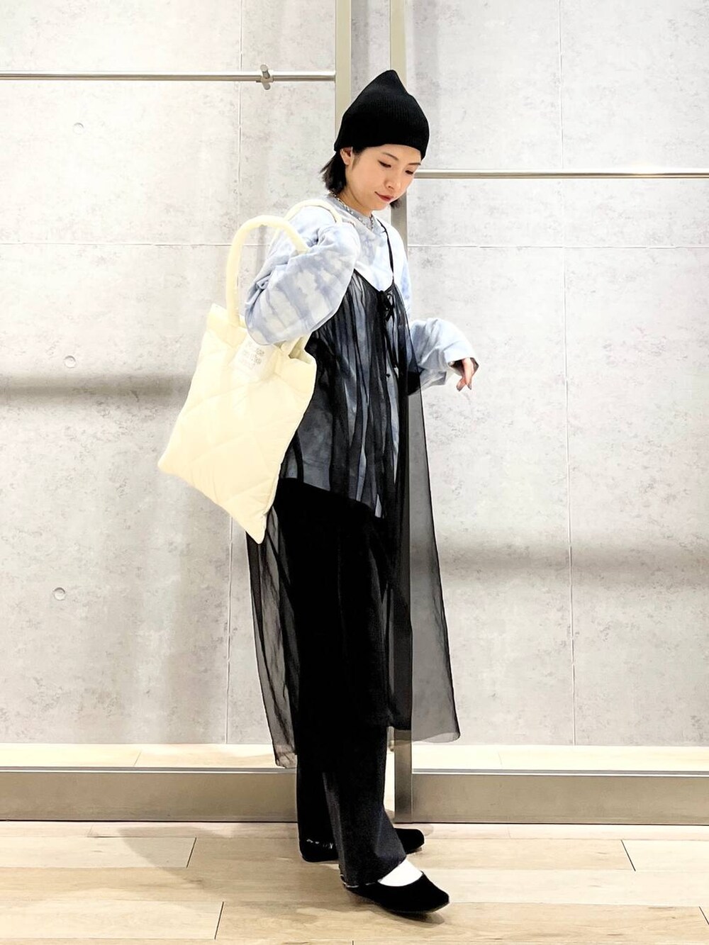 ブラック系のバレエシューズ、ホワイト系のトートバッグ、グレー系のデニムパンツを着用したレディースの冬コーディネートの4枚目の写真