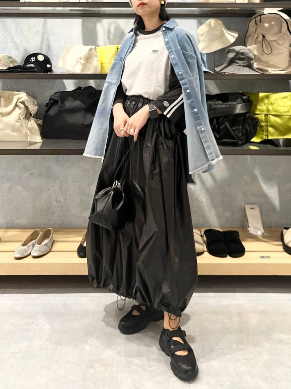 ブラック系のショルダーバッグ、ブラック系のTシャツ/カットソー、ブラック系のスニーカーを着用したレディースの春コーディネートの4枚目の写真