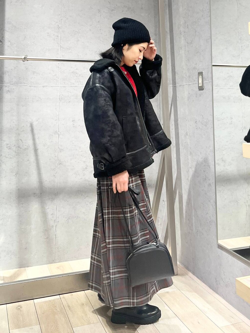 ブラック系のブーツ、ブラック系のその他アウター、グレー系のスカートを着用したレディースの冬コーディネートの6枚目の写真