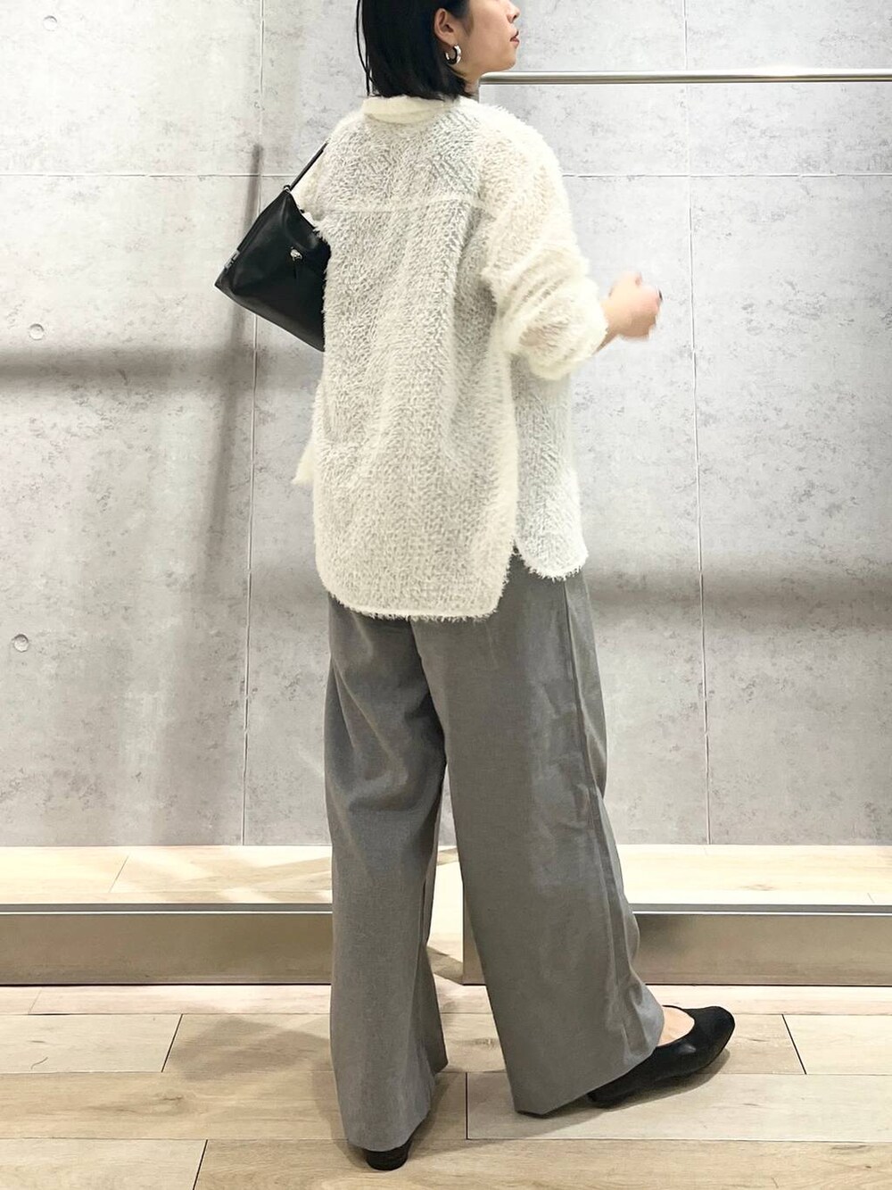 ブラック系のハンドバッグ、ホワイト系のシャツ/ブラウス、ブラック系のパンプスを着用したレディースの春コーディネートの5枚目の写真