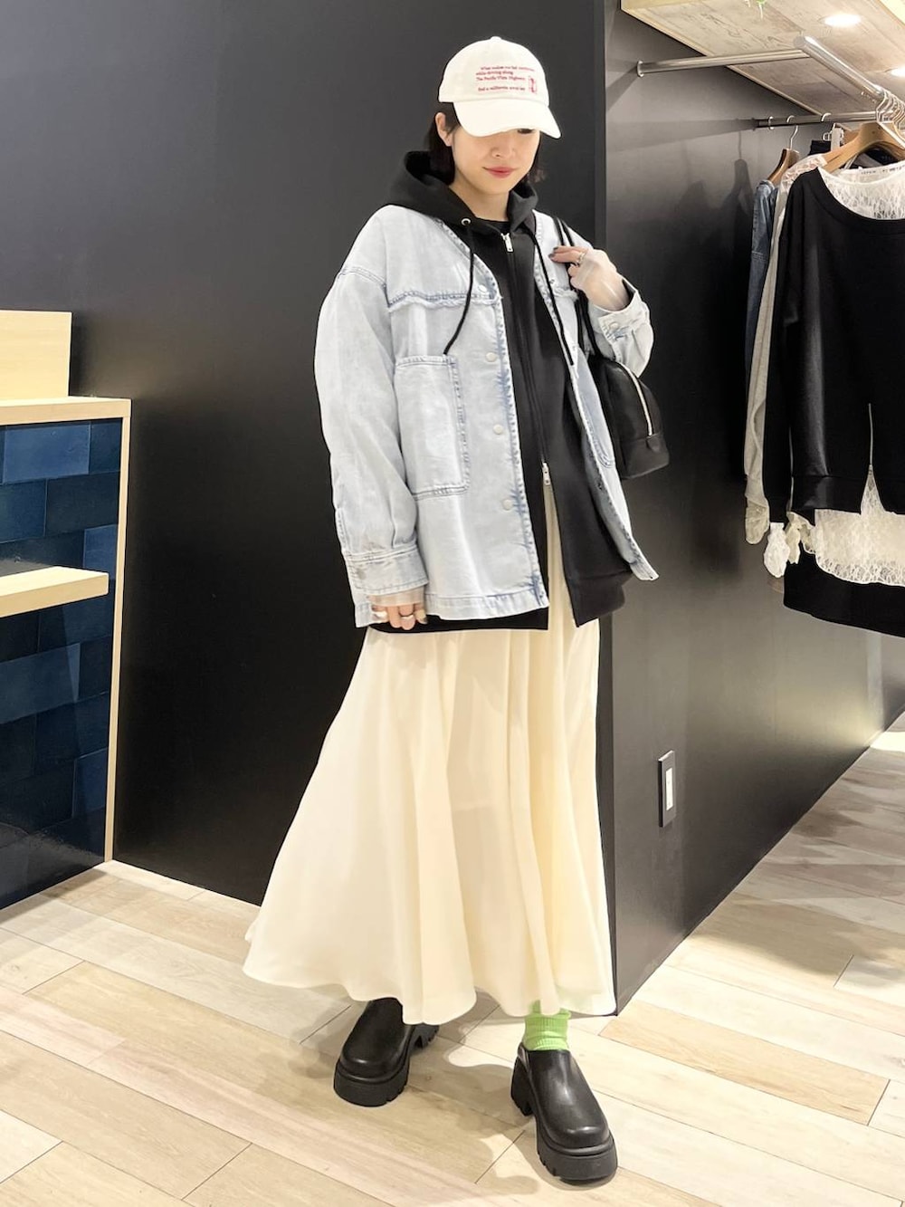 ブラック系のパーカー、ブルー系のシャツ/ブラウス、ブラック系のボストンバッグを着用したレディースの春コーディネートの2枚目の写真