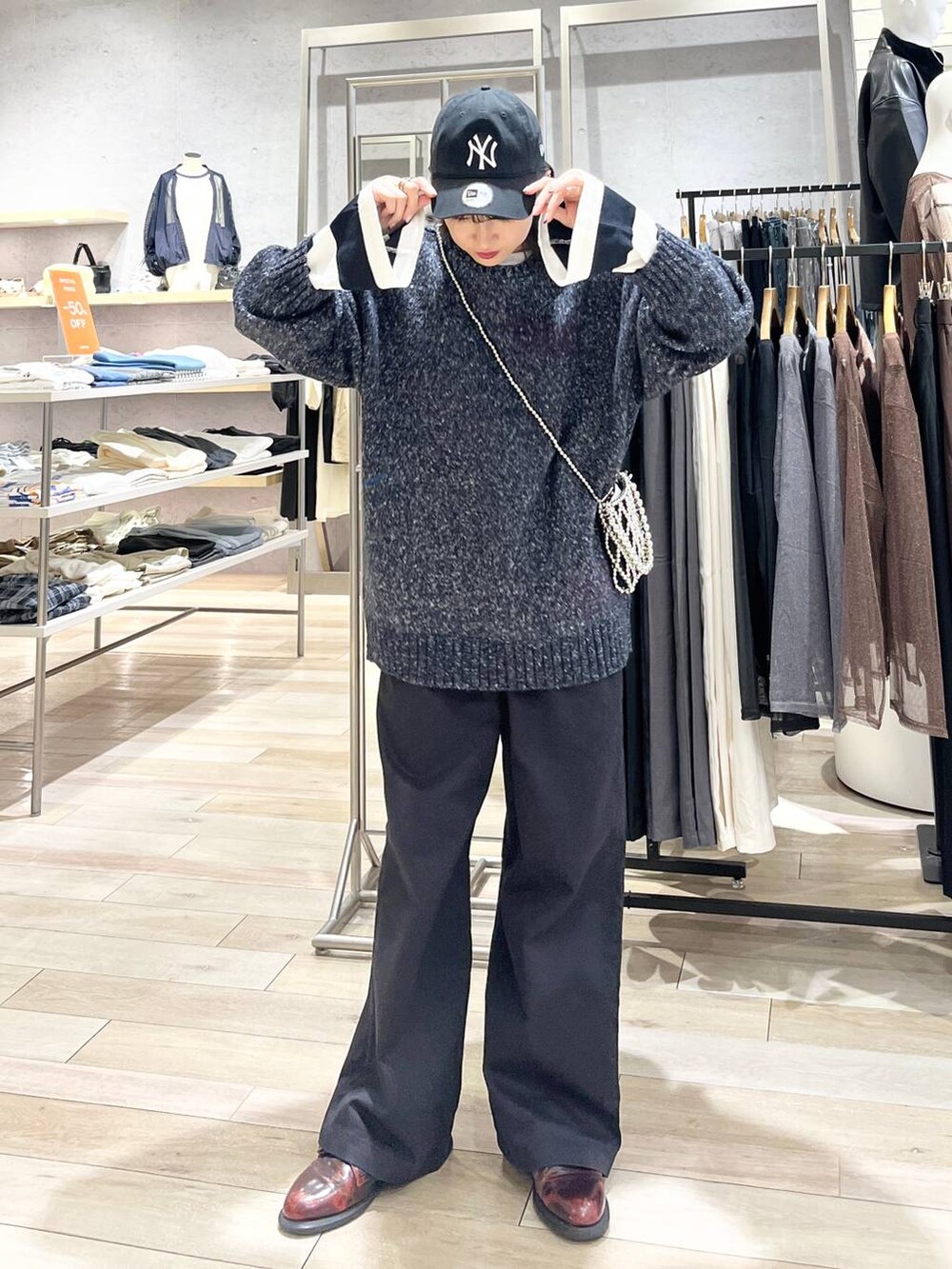 シルバー系のショルダーバッグ、グレー系のチノパンツ、ブラック系のTシャツ/カットソーを着用したレディースの秋コーディネートの6枚目の写真