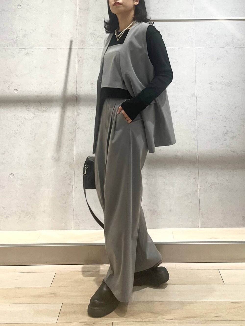 ブラック系のボストンバッグ、グレー系のその他パンツ、ブラック系のサンダルを着用したレディースの春コーディネートの2枚目の写真