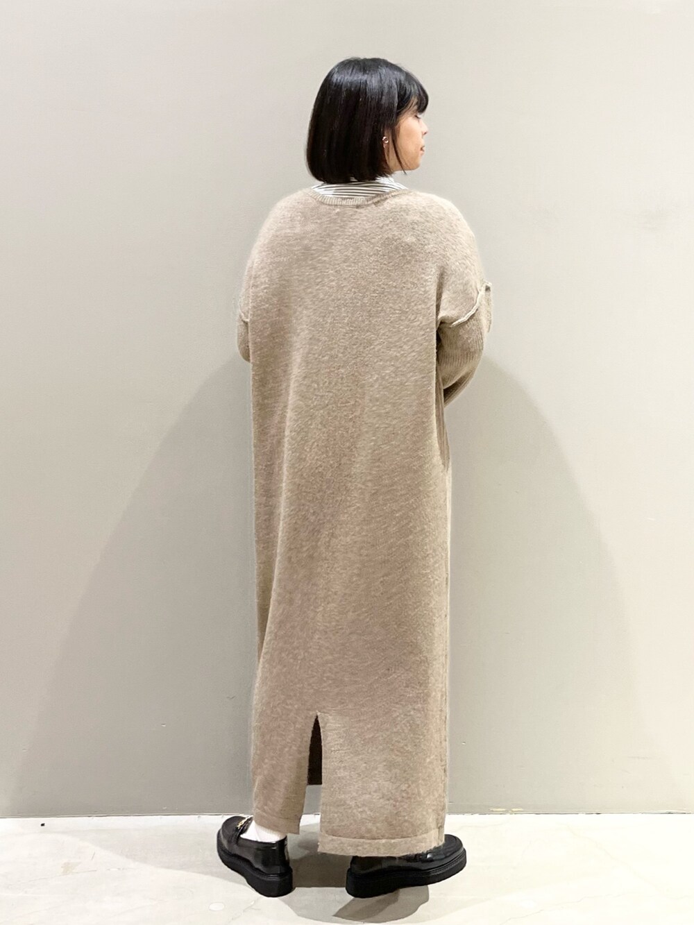 ブラック系のショルダーバッグ、ブラック系のローファー、ブラウン系のワンピースを着用したレディースの冬コーディネートの3枚目の写真