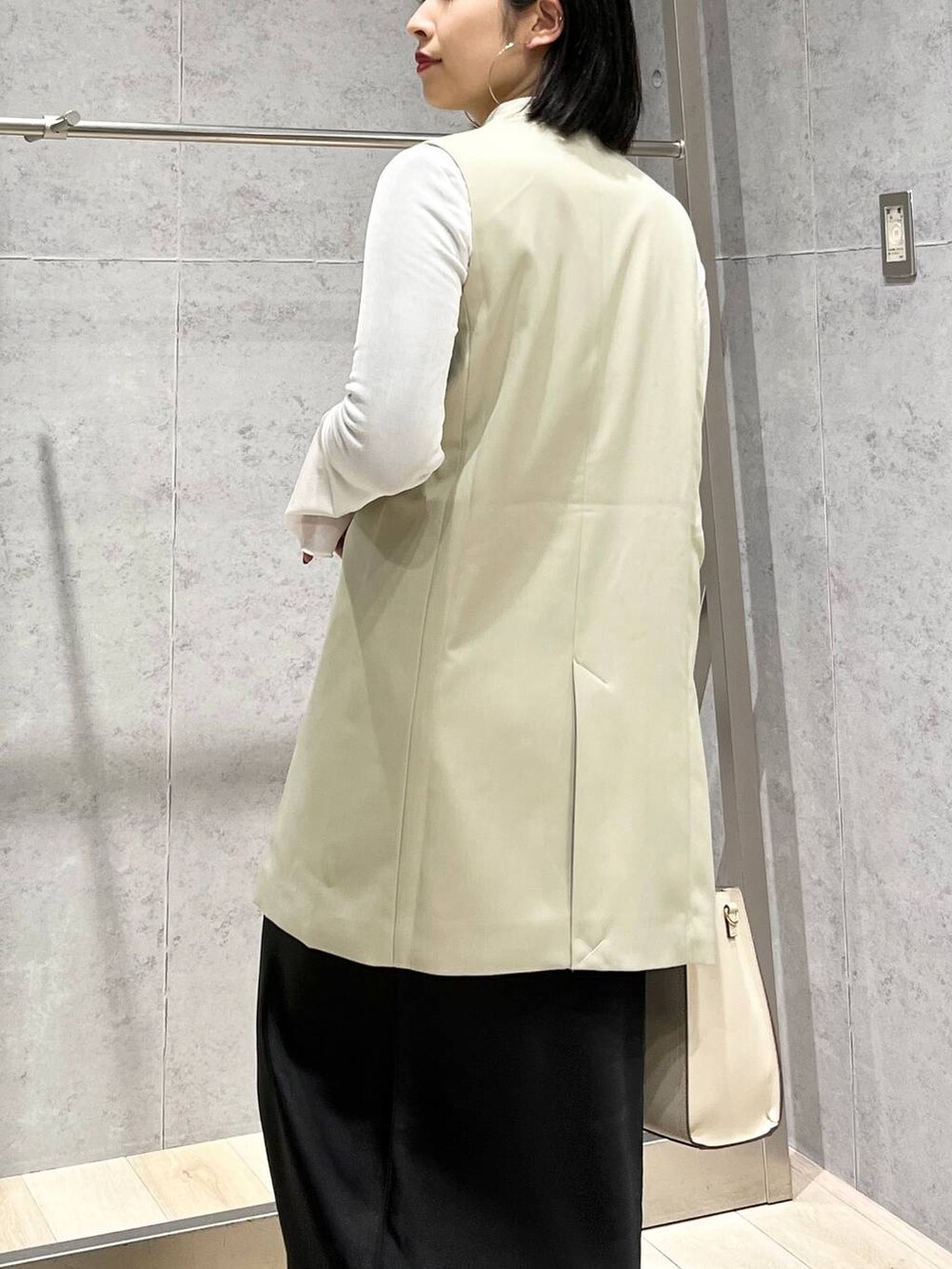 ホワイト系のTシャツ/カットソー、ブラック系のスカート、ホワイト系のショルダーバッグを着用したレディースの冬コーディネートの7枚目の写真