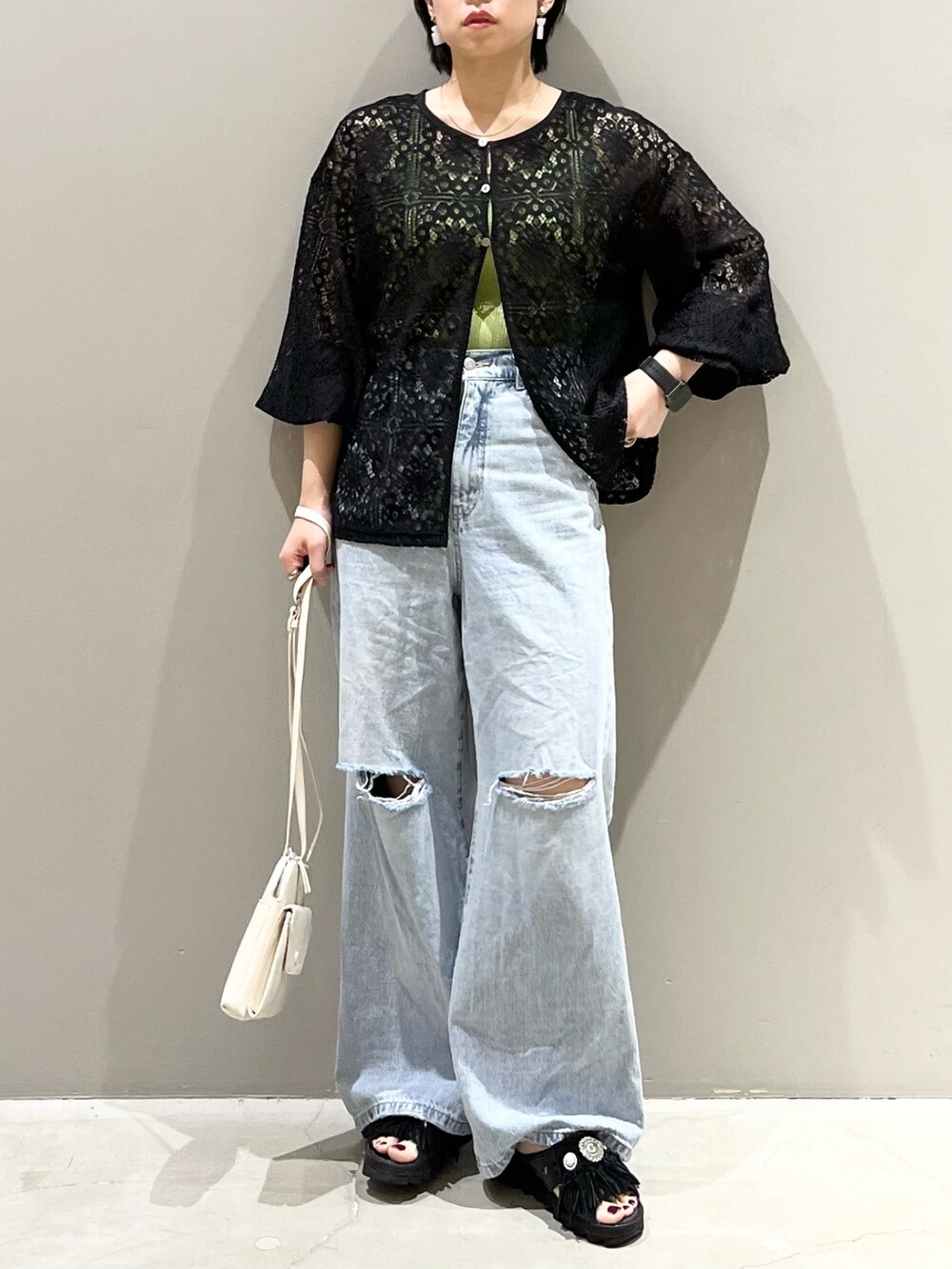 ブラック系のシャツ/ブラウス、ブルー系のデニムパンツ、ブラック系のサンダルを着用したレディースの秋コーディネートの2枚目の写真