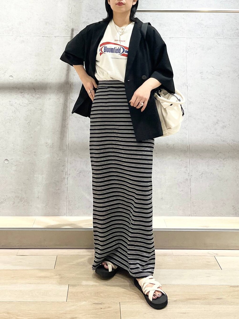 ブラック系のテーラードジャケット、ホワイト系のショルダーバッグ、ホワイト系のTシャツ/カットソーを着用したレディースの夏コーディネートの5枚目の写真