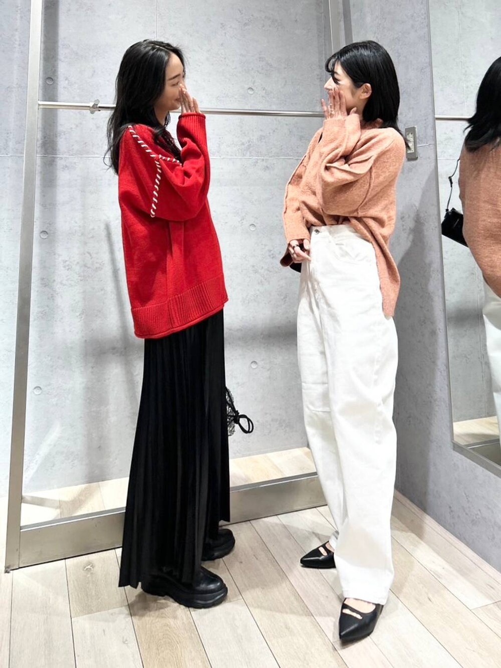 シルバー系のショルダーバッグ、ブラック系のブーツ、ホワイト系のデニムパンツを着用したレディースの冬コーディネートの5枚目の写真