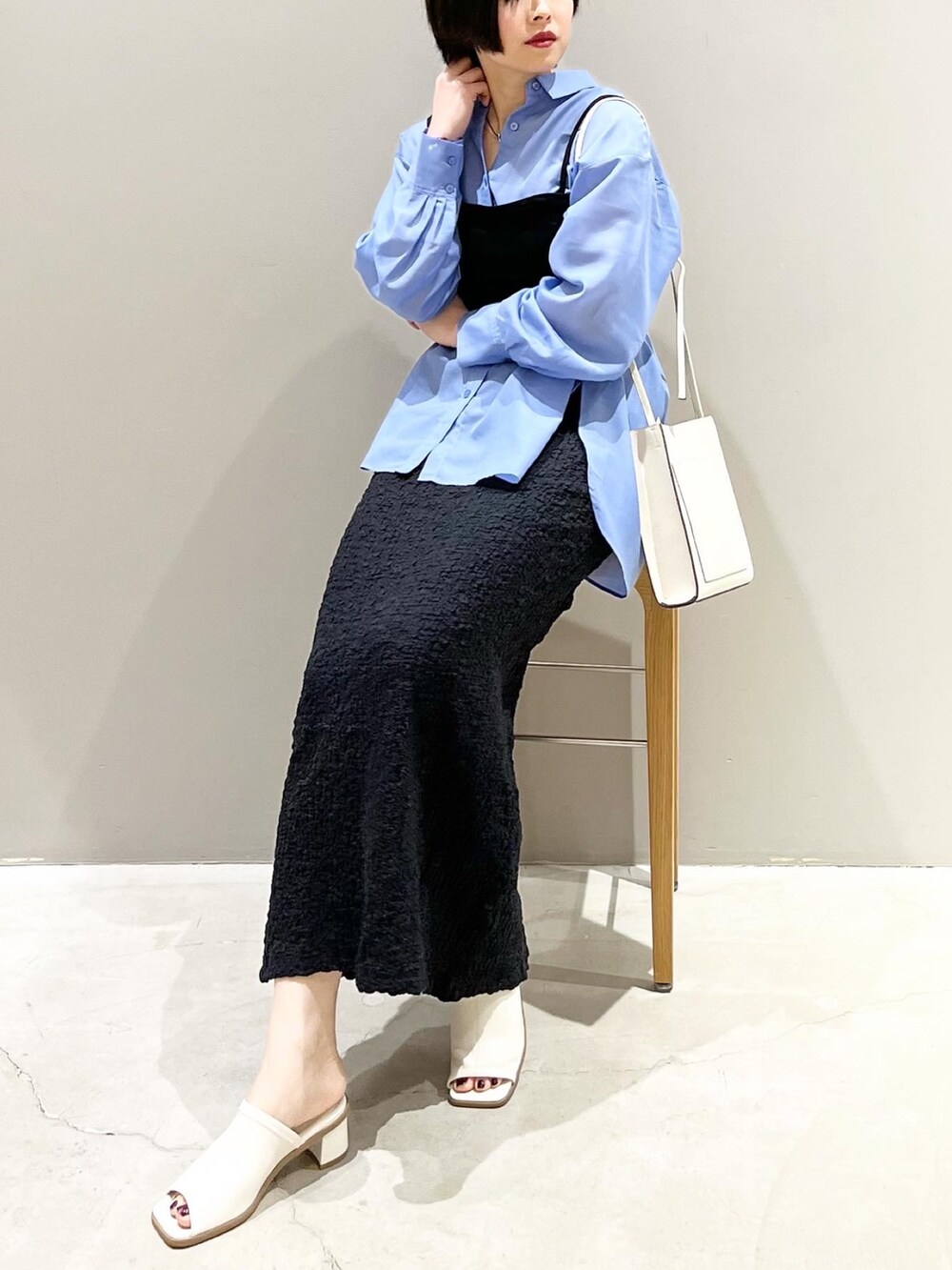 ホワイト系のサンダル、ブラック系のスカート、ブルー系のシャツ/ブラウスを着用したレディースの春コーディネートの2枚目の写真