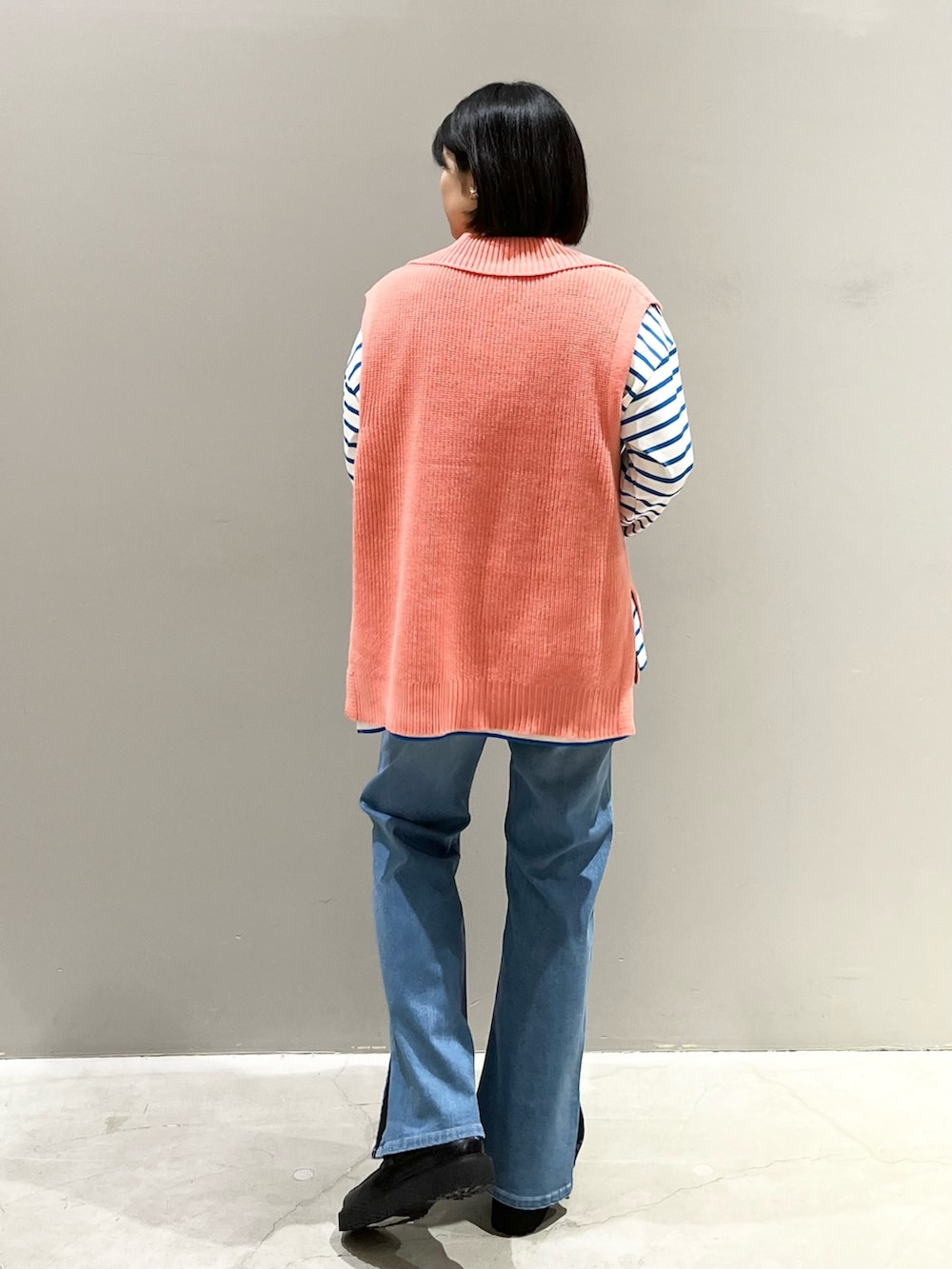 ブルー系のデニムパンツ、ブラック系のローファー、ブラック系のショルダーバッグを着用したレディースの春コーディネートの2枚目の写真