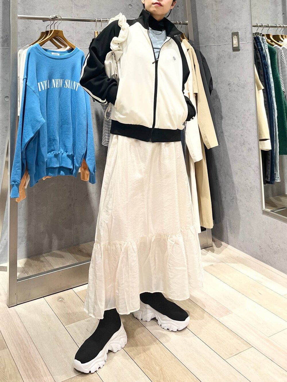 ホワイト系のスカート、ブラック系のブーツ、ブルー系のTシャツ/カットソーを着用したレディースの冬コーディネートの3枚目の写真