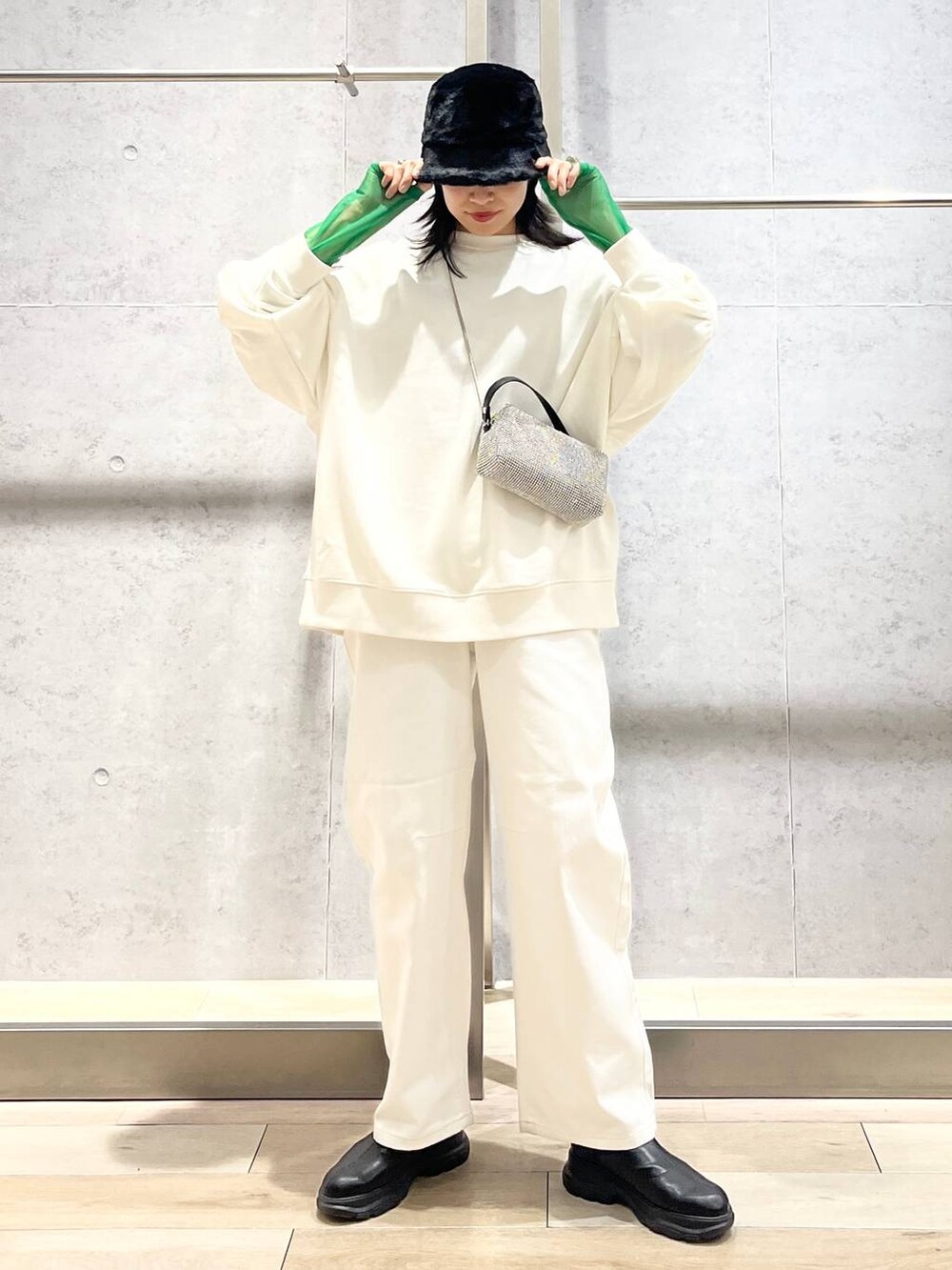 ブラック系のTシャツ/カットソー、ホワイト系のスウェット、ブラック系のブーツを着用したレディースの冬コーディネートの3枚目の写真