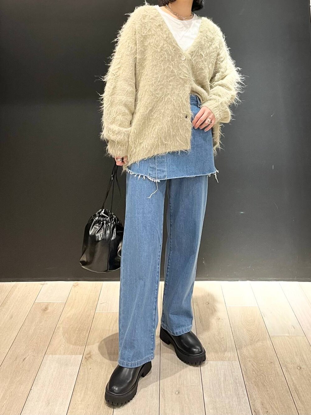 ホワイト系のTシャツ/カットソー、ブラック系のブーツ、ベージュ系のカーディガン/ボレロを着用したレディースの冬コーディネートの5枚目の写真