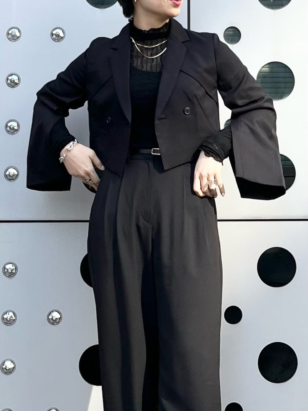 ブラック系のスラックス、ブラック系のブーツ、ブラック系のトップスを着用したレディースの冬コーディネートの3枚目の写真