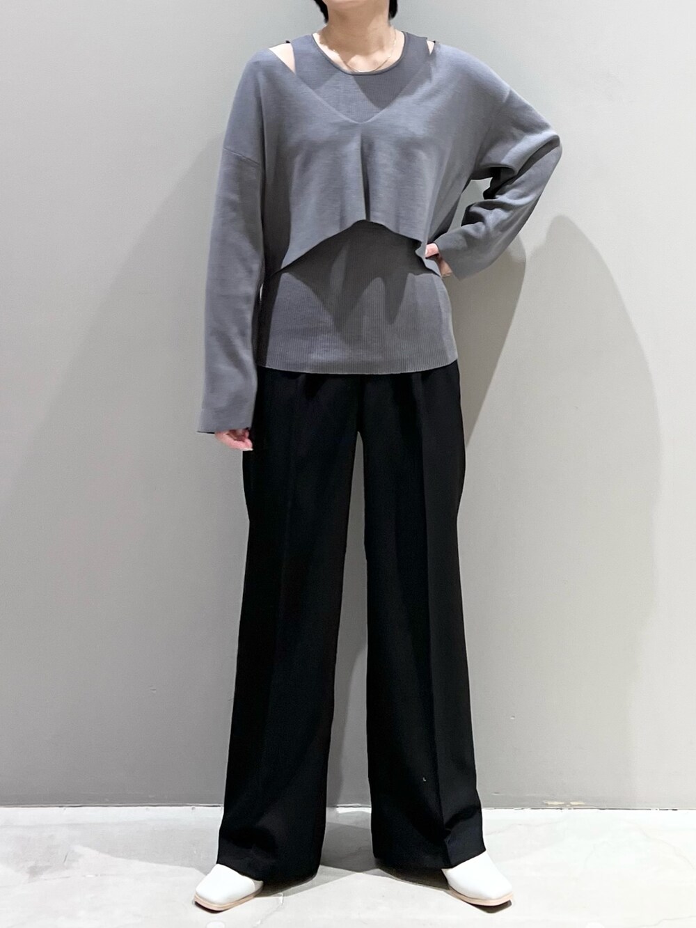 グレー系のニット/セーター、ブラック系のパンツ、ホワイト系のシューズを着用したレディースの春コーディネートの10枚目の写真