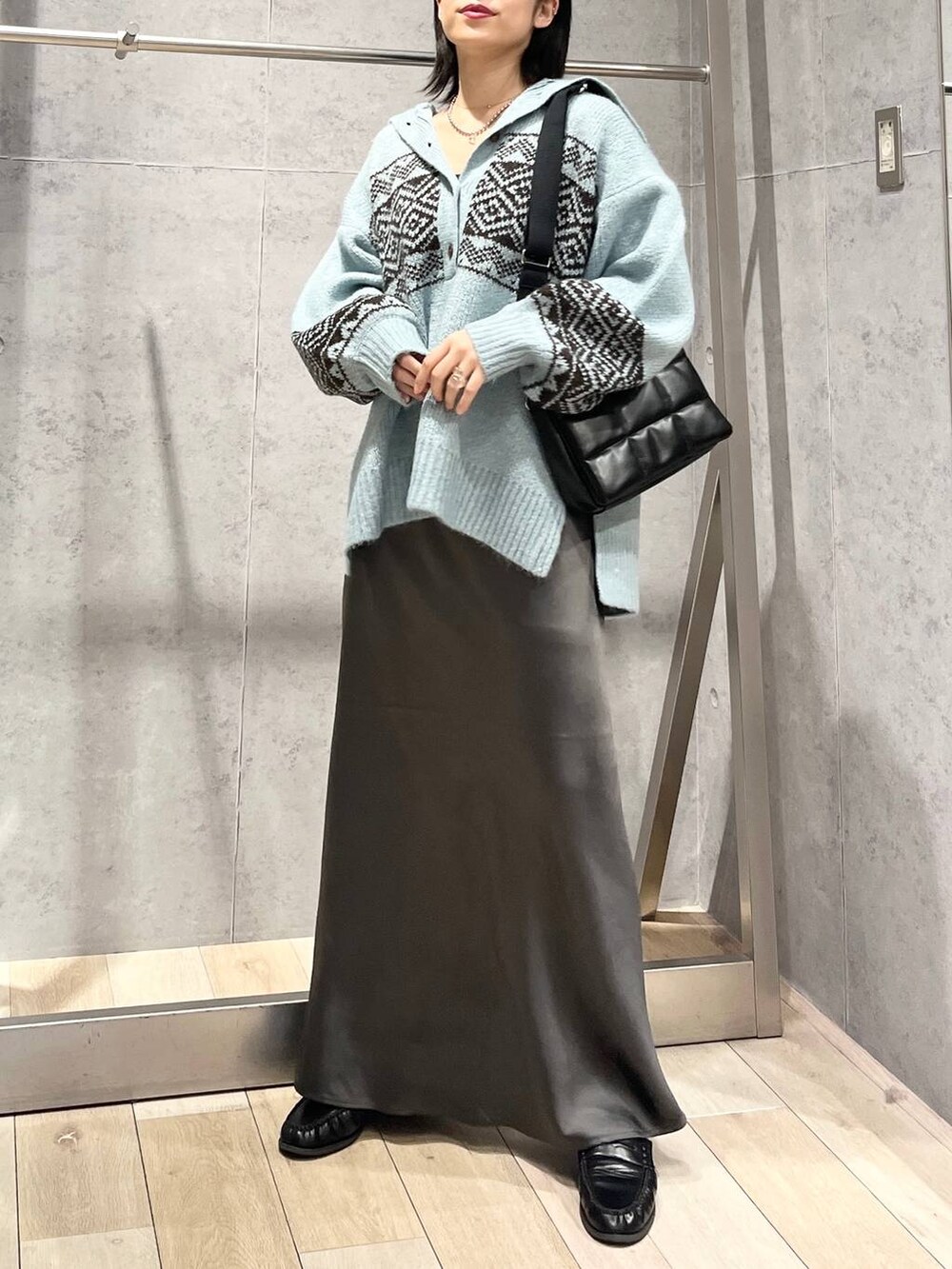ブラック系のショルダーバッグ、グレー系のスカート、ブラック系のローファーを着用したレディースの秋コーディネートの6枚目の写真