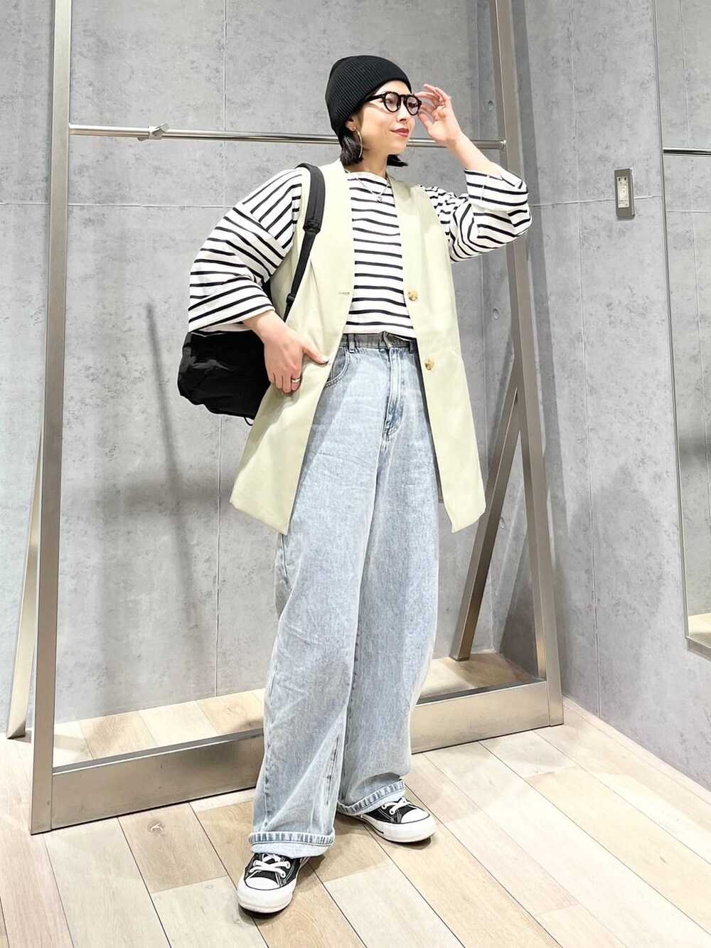 ブラック系のバックパック/リュック、ブルー系のTシャツ/カットソー、ブルー系のデニムパンツを着用したレディースの冬コーディネートの2枚目の写真