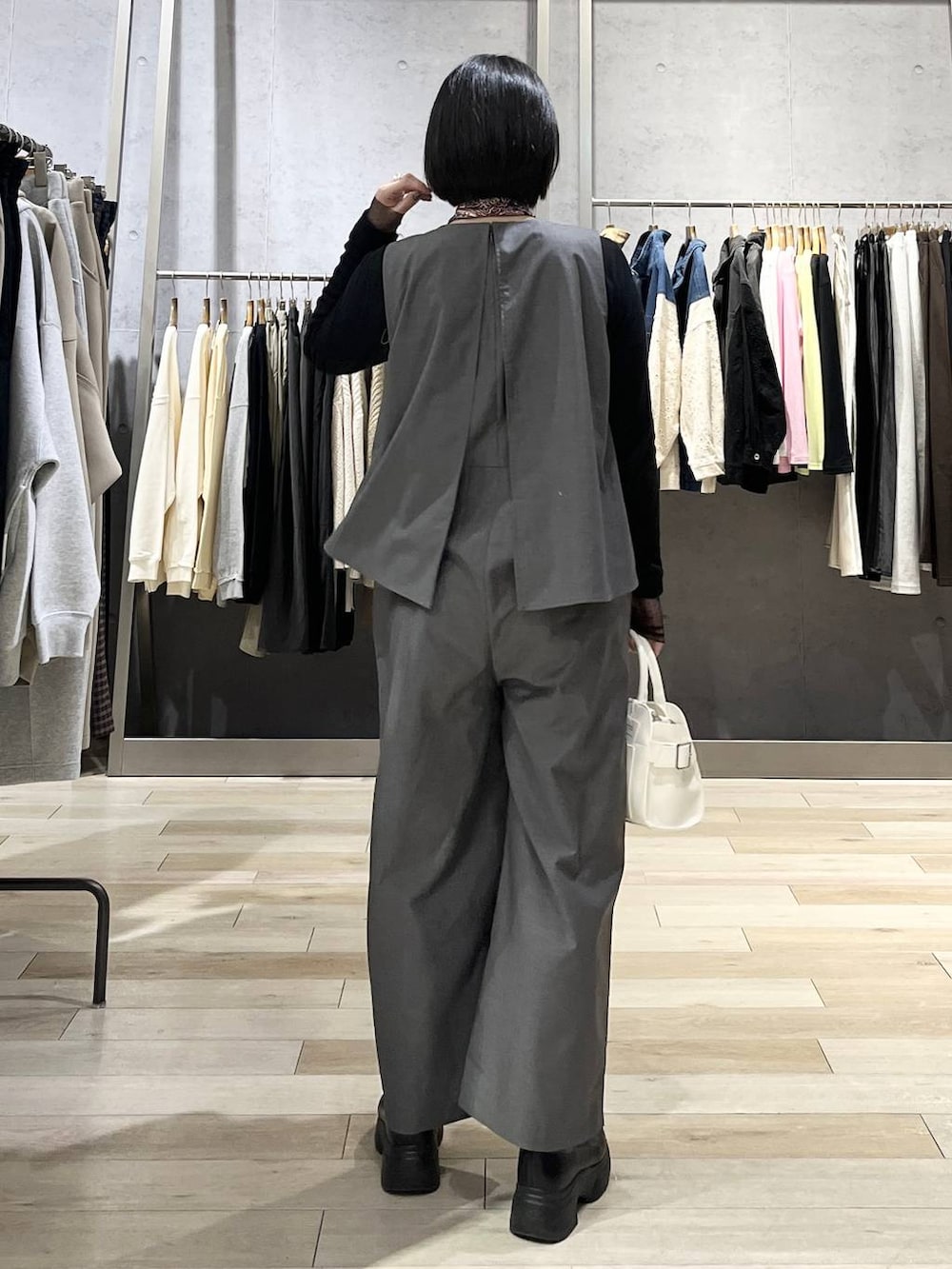 ブラック系のブーツ、ブラック系のTシャツ/カットソー、ホワイト系のショルダーバッグを着用したレディースの冬コーディネートの4枚目の写真