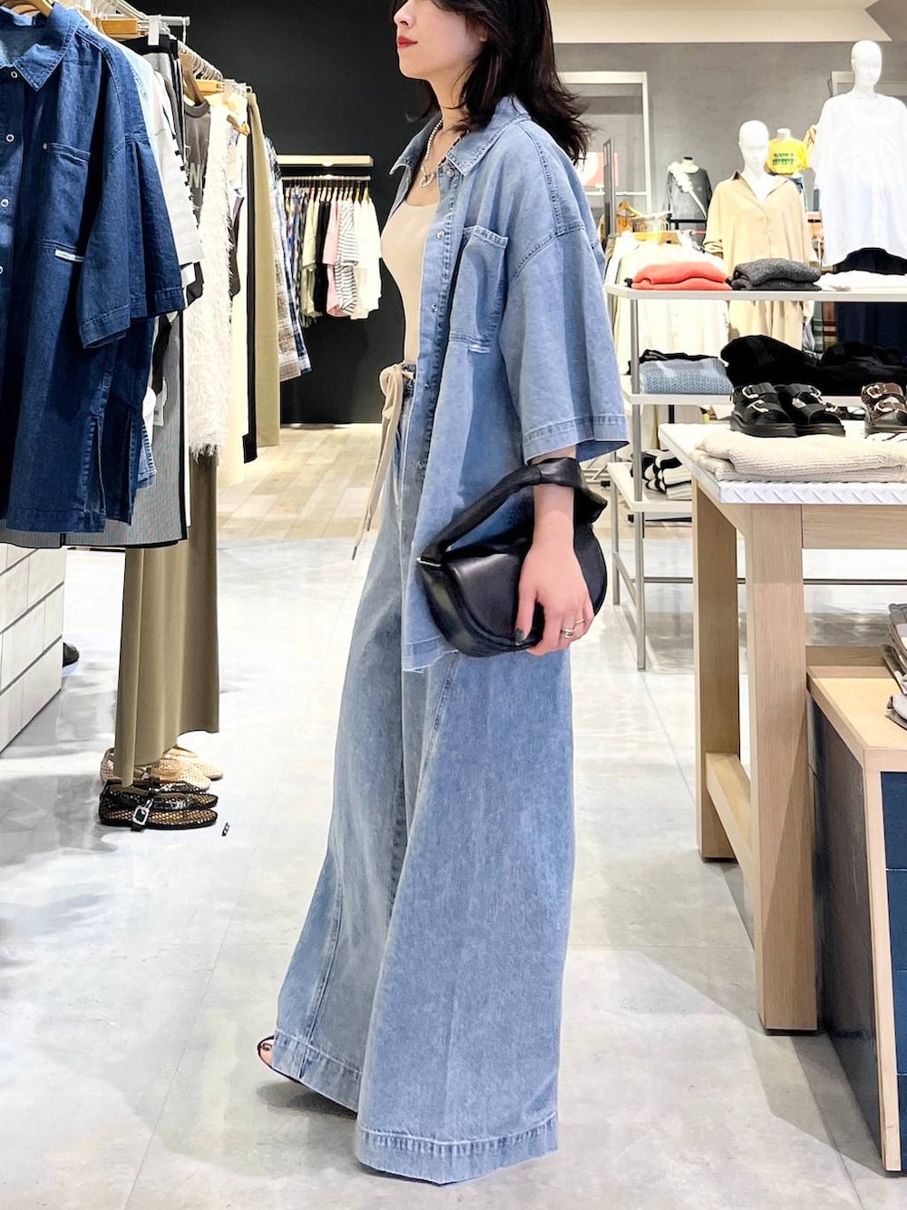 ブルー系のシャツ/ブラウス、ホワイト系のタンクトップ、ブルー系のデニムパンツを着用したレディースの春コーディネートの4枚目の写真