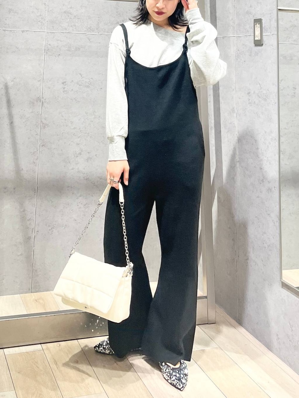 ホワイト系のショルダーバッグ、シルバー系のパンプス、グレー系のスウェットを着用したレディースの秋コーディネートの4枚目の写真