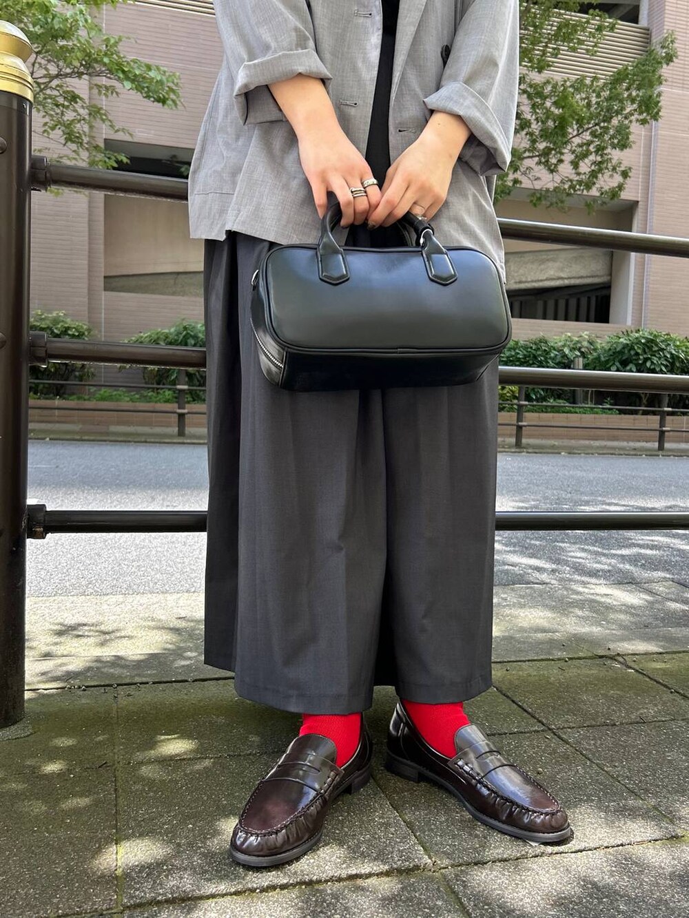 ブラック系のボストンバッグ、グレー系のテーラードジャケット、ブラウン系のローファーを着用したレディースの秋コーディネートの2枚目の写真