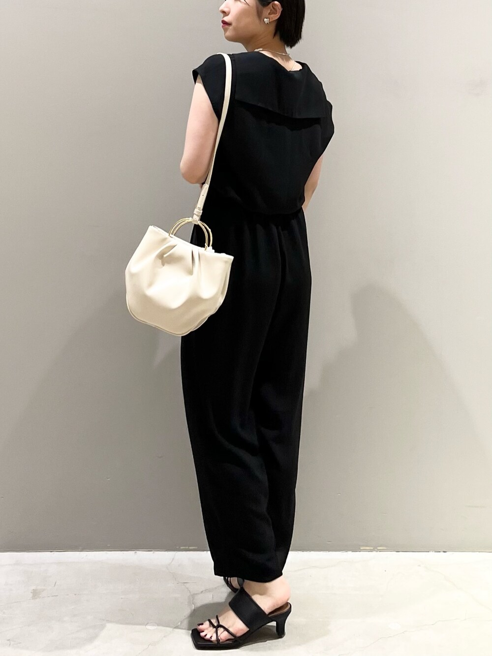 ブラック系のつなぎ/オールインワン、ホワイト系のバッグ、ブラック系のサンダルを着用したレディースの春コーディネートの4枚目の写真