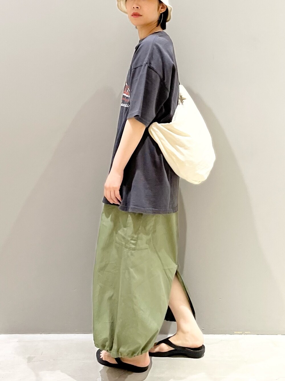 グレー系のTシャツ/カットソー、ホワイト系のショルダーバッグ、グリーン系のスカートを着用したレディースの夏コーディネートの4枚目の写真