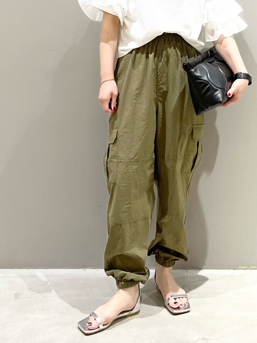 シルバー系のサンダル、ブラック系のバッグ、ホワイト系のTシャツ/カットソーを着用したレディースの秋コーディネートの7枚目の写真