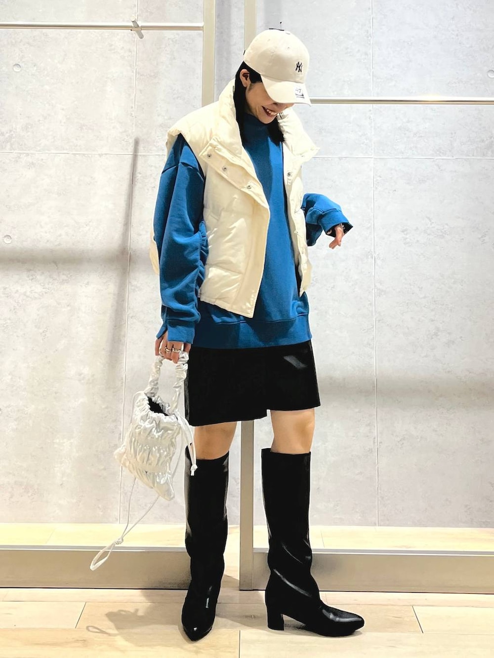 ホワイト系のダウンベスト、シルバー系のショルダーバッグ、ブラック系のその他パンツを着用したレディースの冬コーディネートの8枚目の写真