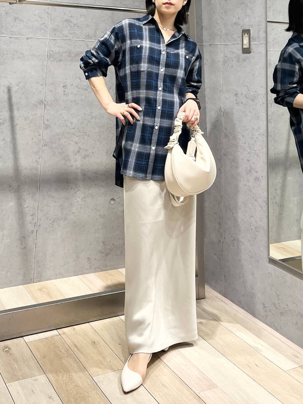 ホワイト系のショルダーバッグ、ホワイト系のスカート、ブルー系のシャツ/ブラウスを着用したレディースの冬コーディネートの9枚目の写真