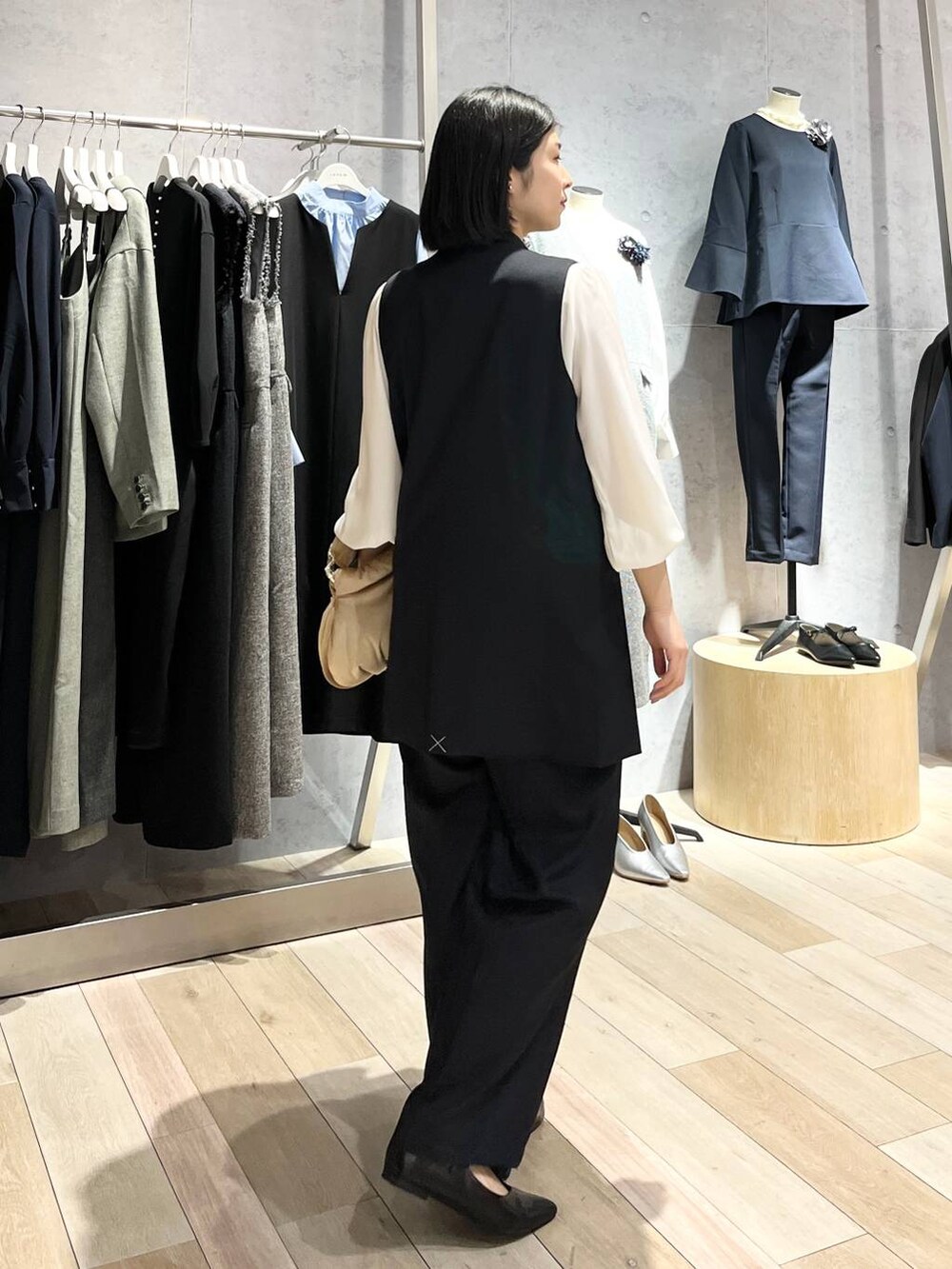 ベージュ系のハンドバッグ、ホワイト系のシャツ/ブラウス、ブラック系のパンプスを着用したレディースの冬コーディネートの8枚目の写真