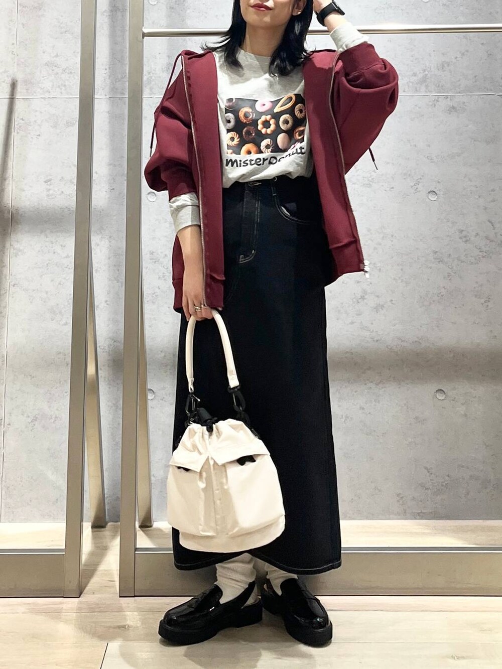 ホワイト系のショルダーバッグ、レッド系のパーカー、ブラック系のデニムスカートを着用したレディースの冬コーディネートの2枚目の写真