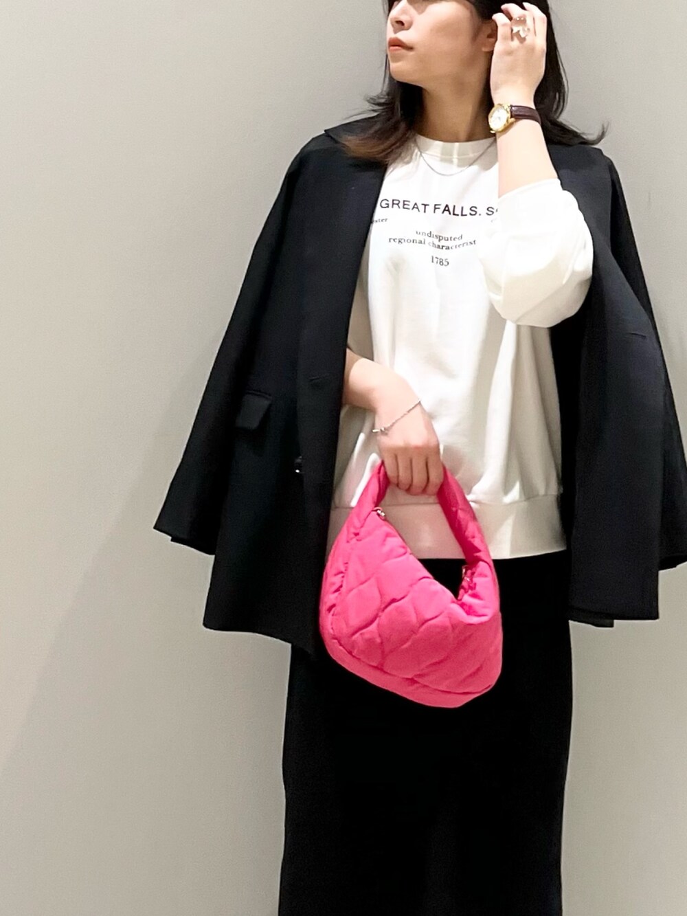 ブラック系のスニーカー、ブラック系のスカート、ピンク系のショルダーバッグを着用したレディースの秋コーディネートの4枚目の写真