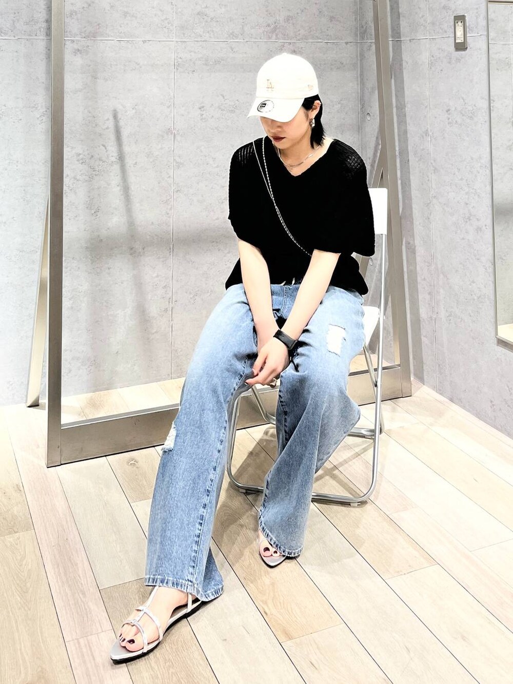 シルバー系のサンダル、ブラック系のニット/セーター、ブルー系のデニムパンツを着用したレディースの春コーディネートの7枚目の写真